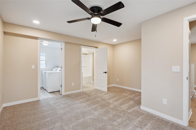 spare room featuring separate washer and dryer and light colored carpet