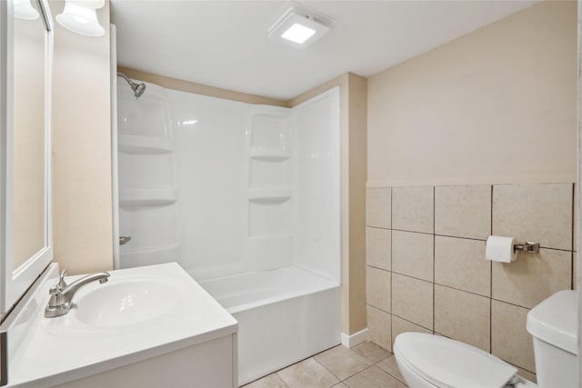 full bathroom with toilet, tile walls, shower / bathtub combination, vanity, and tile patterned flooring