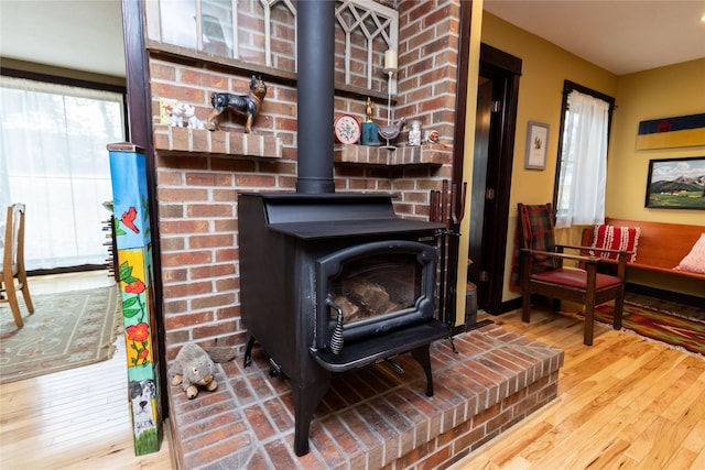 interior details with hardwood / wood-style floors and a wood stove