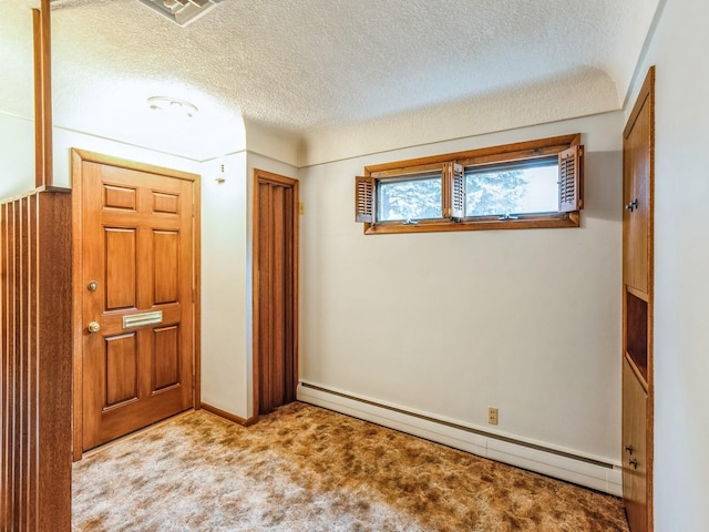 interior space featuring a baseboard heating unit, light colored carpet, a closet, and a textured ceiling