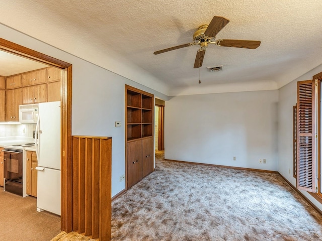 carpeted empty room featuring ceiling fan and a textured ceiling