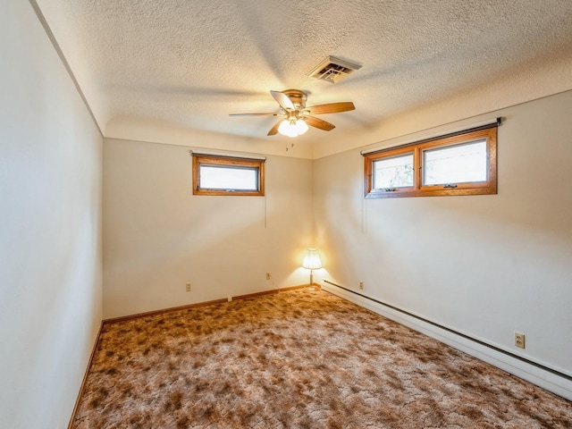 unfurnished room with a wealth of natural light, a baseboard radiator, a textured ceiling, and carpet