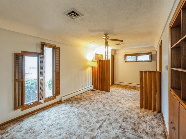 carpeted empty room with ceiling fan, a textured ceiling, and a baseboard heating unit