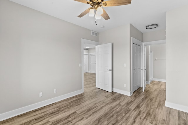 unfurnished bedroom with ceiling fan, a closet, and light hardwood / wood-style flooring