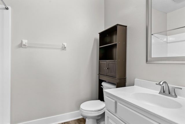 bathroom featuring vanity, hardwood / wood-style floors, and toilet