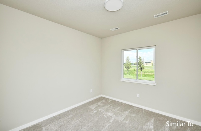 carpeted empty room with a textured ceiling