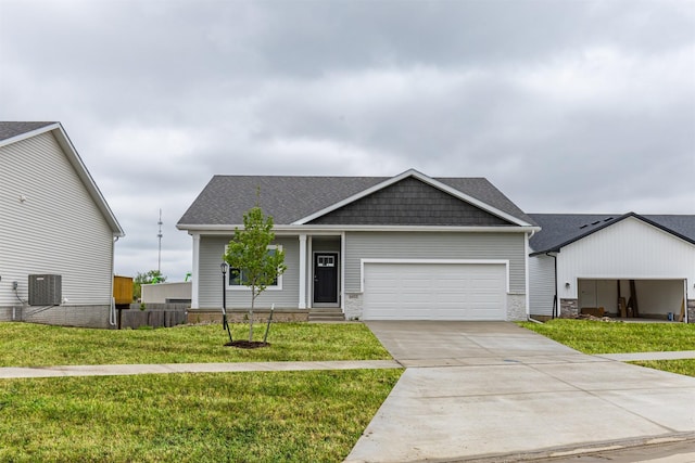 6433 NE 11th Ct, Des Moines, IA 50313 - view of front facade featuring an attached garage, a front lawn, concrete driveway, central AC unit, and stone siding
