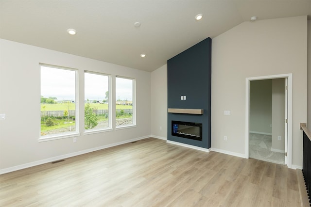 6433 NE 11th Ct, Des Moines, IA 50313 - unfurnished living room with light wood-type flooring, a fireplace, recessed lighting, baseboards, and high vaulted ceiling