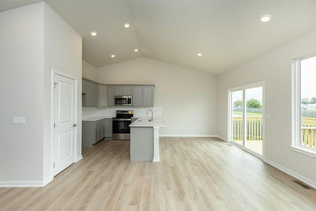 6433 NE 11th Ct, Des Moines, IA 50313 - kitchen with stainless steel appliances, gray cabinets, a sink, decorative backsplash, and lofted ceiling