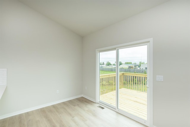 6433 NE 11th Ct, Des Moines, IA 50313 - spare room featuring light wood-type flooring, baseboards, and vaulted ceiling