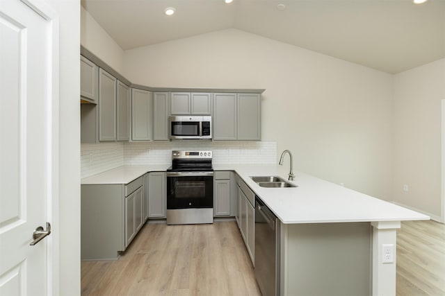 6433 NE 11th Ct, Des Moines, IA 50313 - kitchen featuring stainless steel appliances, gray cabinetry, a sink, a peninsula, and light wood-type flooring