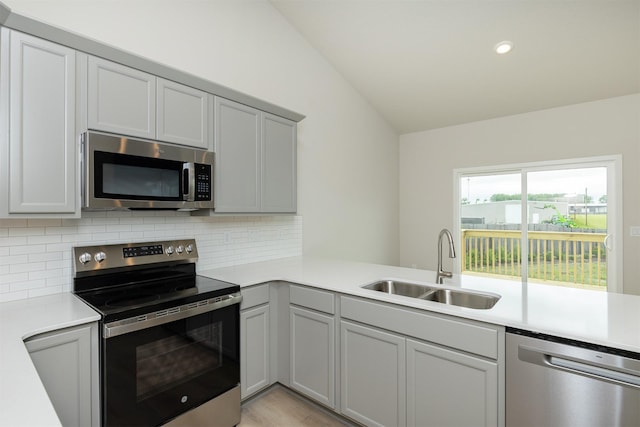 6433 NE 11th Ct, Des Moines, IA 50313 - kitchen featuring stainless steel appliances, a sink, gray cabinets, light countertops, and backsplash