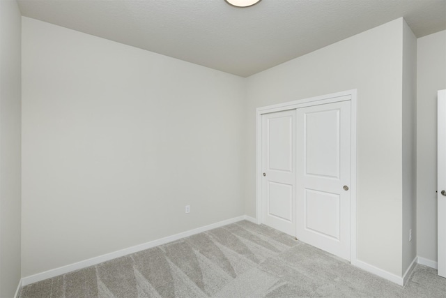 6433 NE 11th Ct, Des Moines, IA 50313 - unfurnished bedroom featuring light carpet, baseboards, and a closet