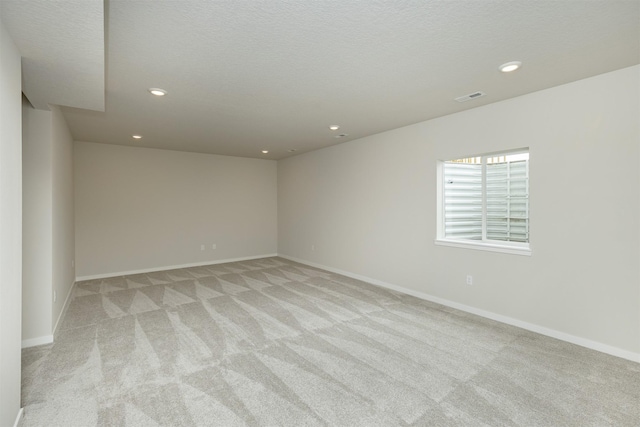 6433 NE 11th Ct, Des Moines, IA 50313 - spare room with light colored carpet, recessed lighting, baseboards, and a textured ceiling