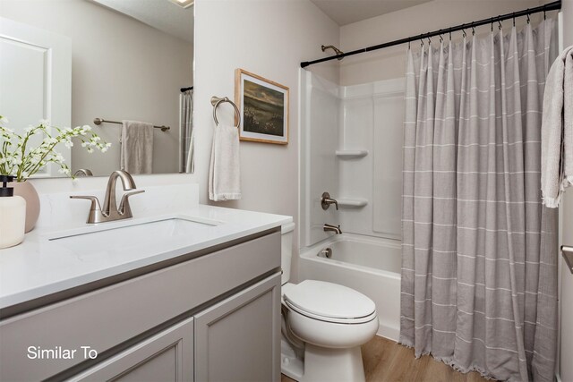 full bath featuring vanity, toilet, wood finished floors, and shower / tub combo with curtain