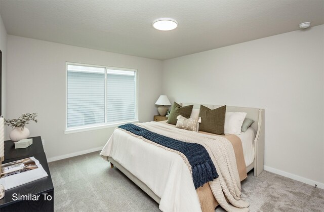 carpeted bedroom with baseboards and a textured ceiling