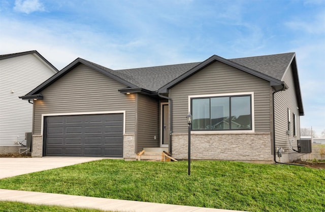 ranch-style house featuring an attached garage, a front lawn, driveway, and roof with shingles