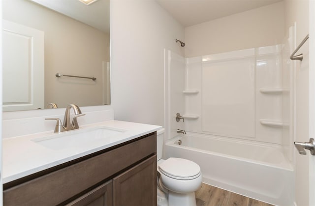 full bathroom with shower / washtub combination, toilet, vanity, and wood finished floors