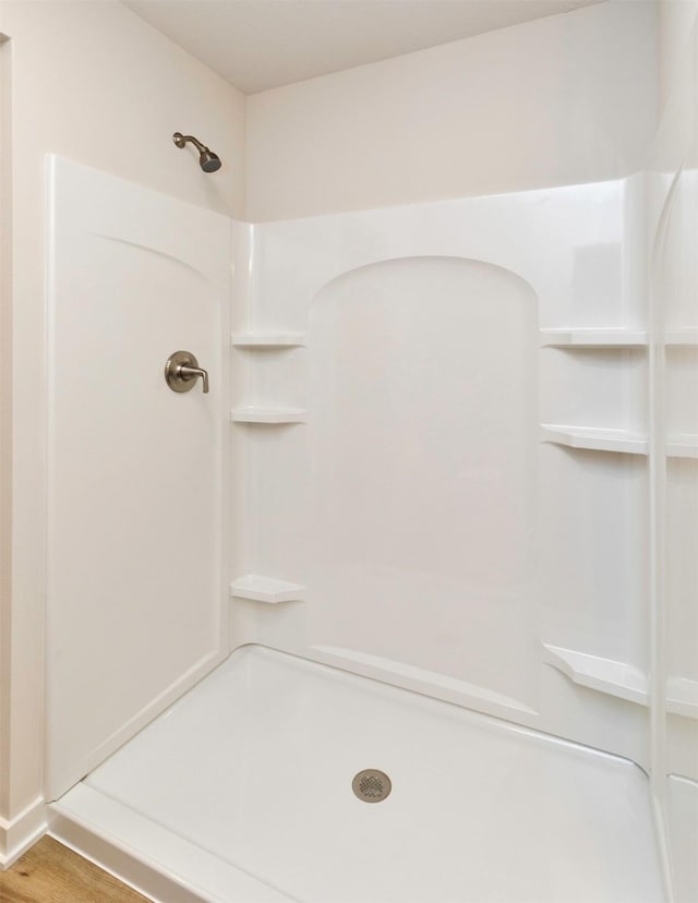 full bath featuring wood finished floors and a shower