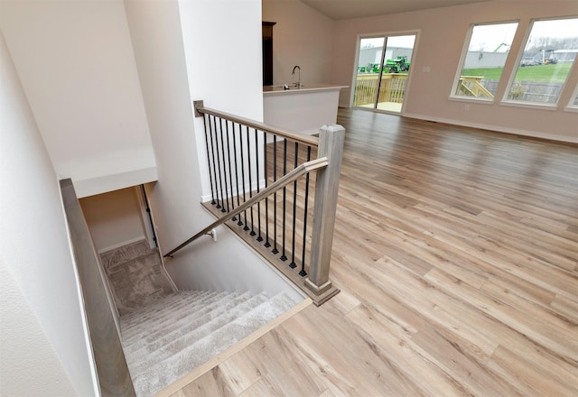 staircase featuring baseboards and wood finished floors