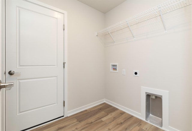 clothes washing area featuring hookup for an electric dryer, baseboards, light wood-style floors, hookup for a washing machine, and laundry area