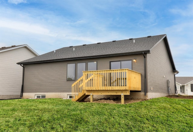 rear view of house featuring a shingled roof, a yard, and a deck