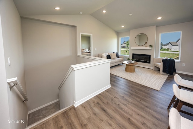 6443 NE 11th Ct, Des Moines, IA 50313 - living room featuring vaulted ceiling, wood finished floors, baseboards, recessed lighting, and a glass covered fireplace