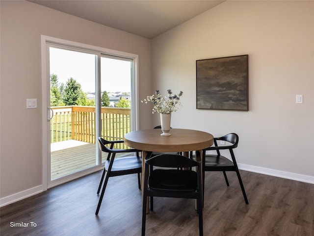 dining space with dark hardwood / wood-style flooring and vaulted ceiling