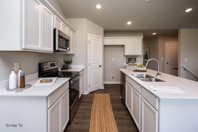 kitchen with stainless steel appliances, an island with sink, sink, and white cabinets