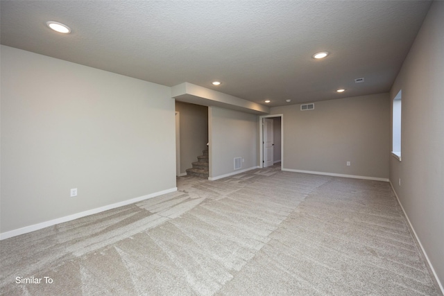 carpeted empty room featuring a textured ceiling