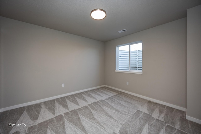 carpeted spare room with a textured ceiling