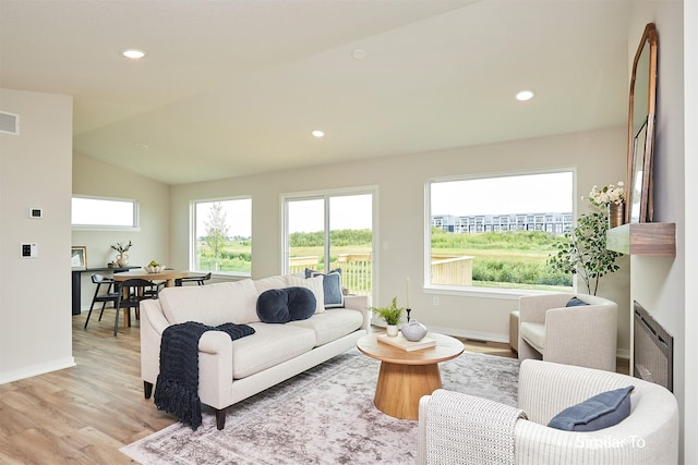 living room with vaulted ceiling and light hardwood / wood-style flooring