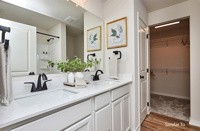 bathroom featuring vanity, hardwood / wood-style floors, and a shower