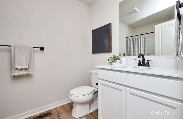 bathroom with vanity, hardwood / wood-style floors, curtained shower, and toilet