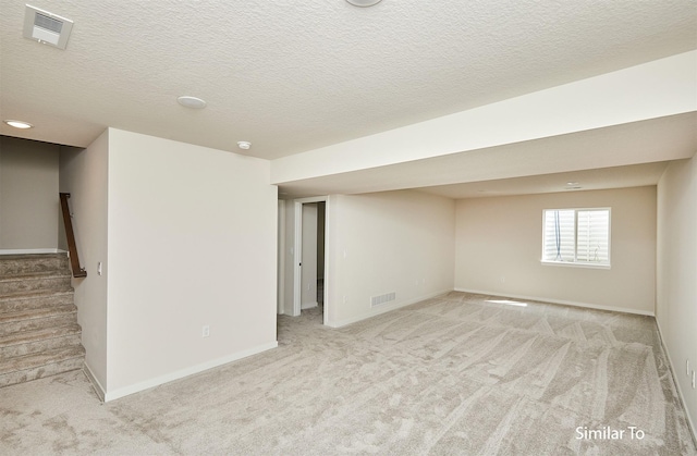 carpeted empty room with a textured ceiling