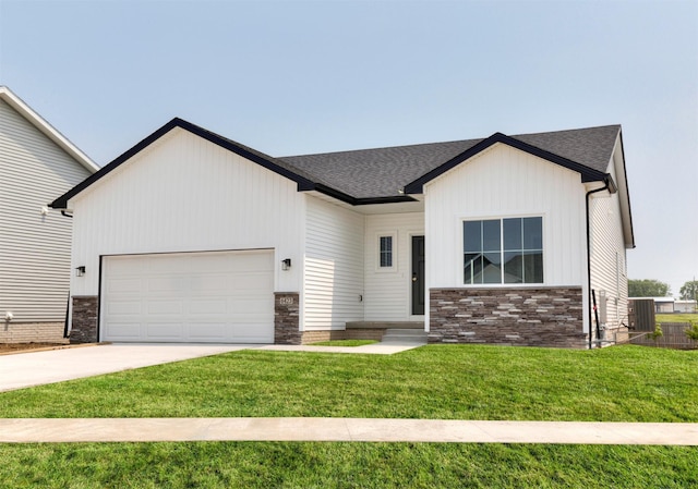 6423 NE 11th Ct, Des Moines, IA 50313 - view of front of home with a garage, driveway, a front lawn, a shingled roof, and stone siding