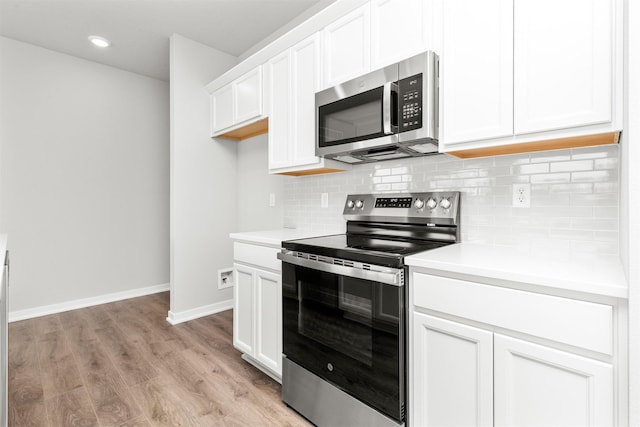 6423 NE 11th Ct, Des Moines, IA 50313 - kitchen featuring appliances with stainless steel finishes, backsplash, light countertops, light wood-style flooring, and recessed lighting