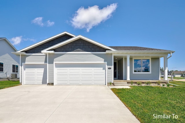 view of front of home with a garage, a front yard, and central air condition unit