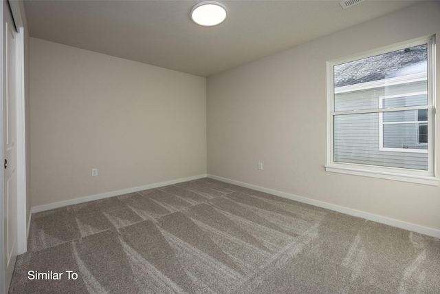 unfurnished room featuring carpet floors and baseboards