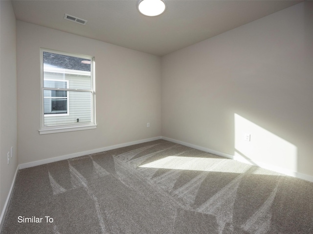 carpeted spare room with baseboards and visible vents