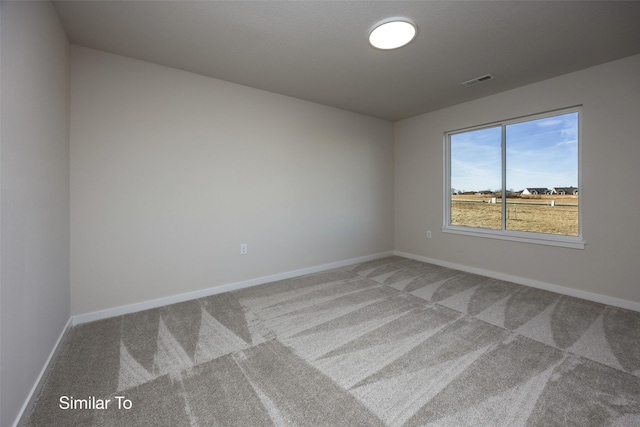 carpeted spare room with baseboards and visible vents