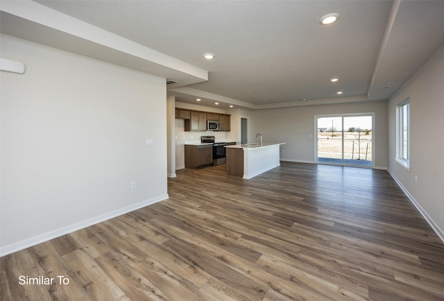 unfurnished living room featuring dark hardwood / wood-style flooring and sink