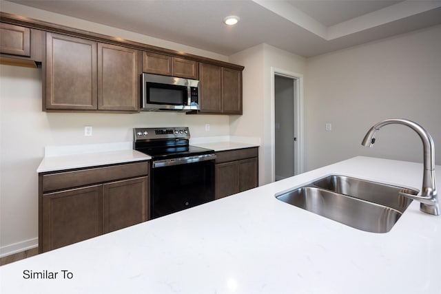 kitchen featuring dark brown cabinetry, black range with electric stovetop, and sink