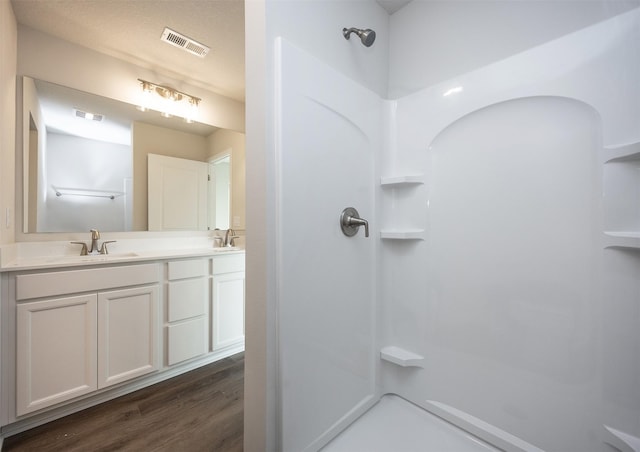 bathroom with visible vents, a sink, and a shower