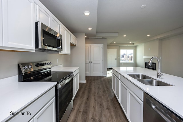 kitchen with stainless steel appliances, white cabinetry, sink, and dark wood-type flooring