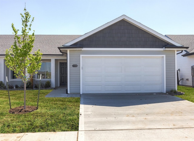 2228 Legacy Dr, Norwalk, IA 50211 - ranch-style house featuring concrete driveway, an attached garage, roof with shingles, and a front yard