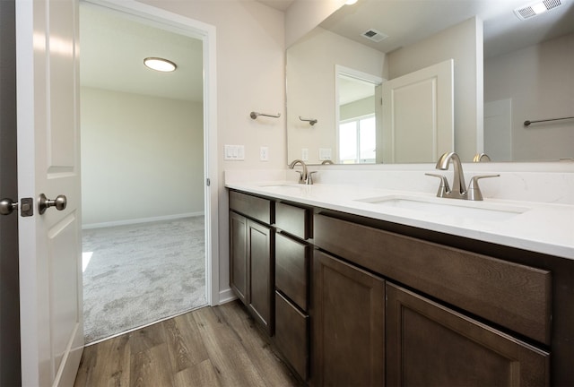 2228 Legacy Dr, Norwalk, IA 50211 - full bathroom with wood finished floors, double vanity, and baseboards
