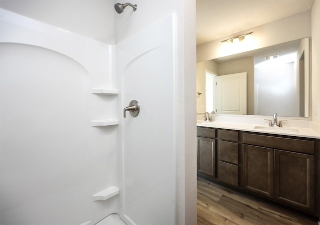 2228 Legacy Dr, Norwalk, IA 50211 - full bath featuring wood finished floors, double vanity, and a shower