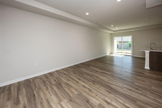 2228 Legacy Dr, Norwalk, IA 50211 - unfurnished living room featuring recessed lighting, wood finished floors, baseboards, and a sink