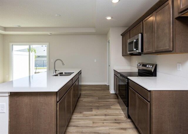 2228 Legacy Dr, Norwalk, IA 50211 - kitchen with stainless steel appliances, a sink, light wood finished floors, a center island with sink, and recessed lighting